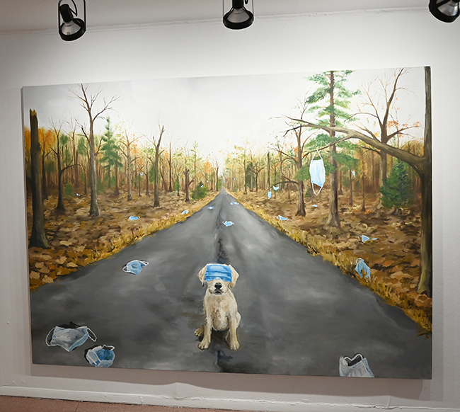 Floor to ceiling painting of dog on forest path with masks strewn everywhere